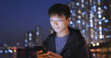 Adam cep telefonuyla şehirde geceleri 