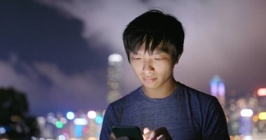 Smartphone şehirde geceleri kullanan adam 