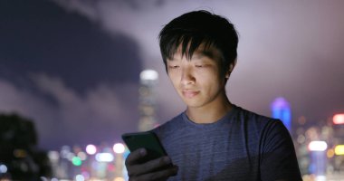 Adam cep telefonuyla şehirde geceleri 