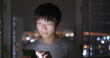 Evde cep telefonu kullanan adam. 