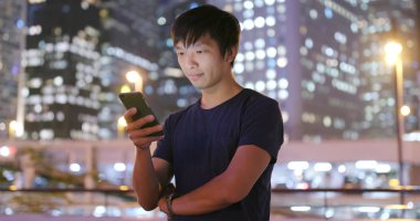 Adam cep telefonuyla şehirde geceleri 