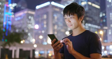 Gece şehirde cep telefonu kullanan adam 