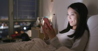 Akşamları evde cep telefonu kullanan kadın 