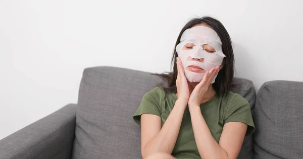 女性自宅の顔にマスクを適用します — ストック写真