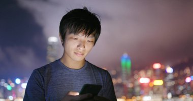 Adam cep telefonuyla şehirde geceleri 