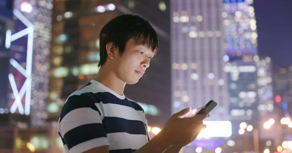 Man checking on cellphone at night