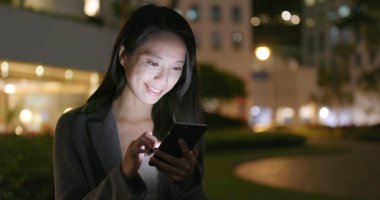 İşkadını Smartphone şehirde geceleri kullanarak.