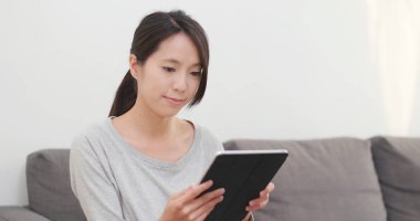 evde tablet bilgisayar kullanan kadın