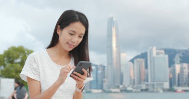 Kadın, şehirdeki akıllı telefona bak.