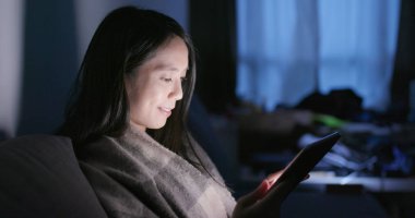 Akşamları evde tablet bilgisayarda izlerken kadın