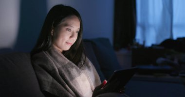 Geceleri tablet bilgisayar kullanan kadın