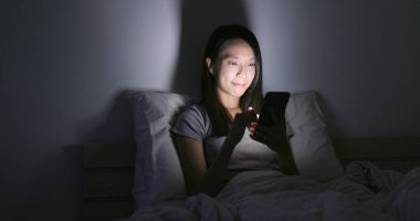 Evde cep telefonu kullanan bir kadın