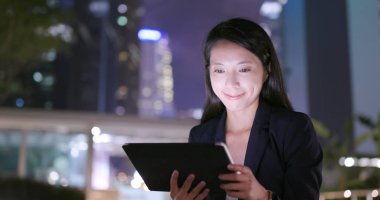 Geceleri dijital tablet bilgisayar kullanarak iş kadını