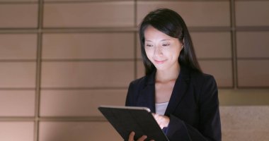 İş kadını geceleri tablet bilgisayarda çalışıyor