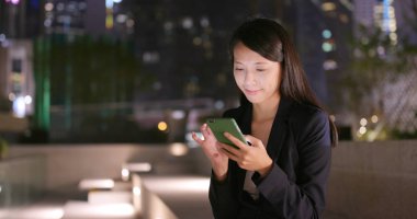 Geceleri cep telefonu kullanan genç iş kadını