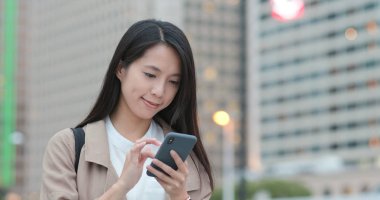 Şehirde akıllı telefon kullanan bir kadın