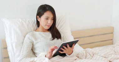 Yatağa tablet kullanan kadın
