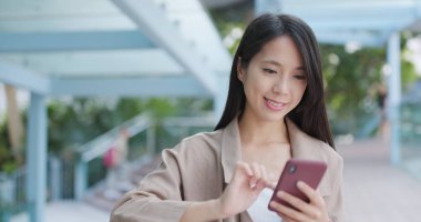 Şehirde akıllı telefon kullanan bir kadın.