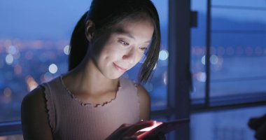 Cep telefonu evde akşamları kullanan kadın