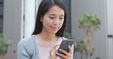 Şehirde akıllı telefon kullanan bir kadın