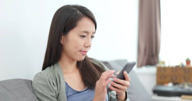 Evde cep telefonu kullanan bir kadın