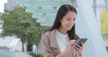 Cep telefonu ve gülümseme kullanan kadın kamera için