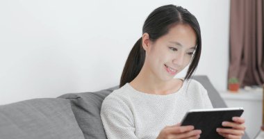 Kadın evde tablet bilgisayarda okuma