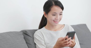 Evde cep telefonu kullanan bir kadın