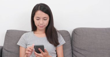 Evde cep telefonu kullanan bir kadın