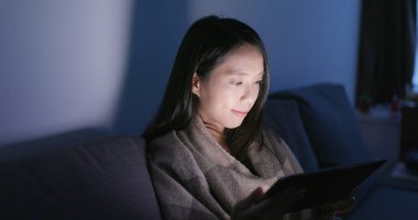 Genç tablet bilgisayar ve duygu göz ağrısı evde akşamları kullanan kadın