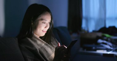 Cep telefonu evde akşamları kullanan kadın