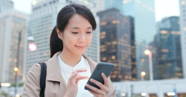 Şehirde akıllı telefon kullanan bir kadın