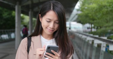 Şehirde cep telefonu kullanan genç bir kadın.