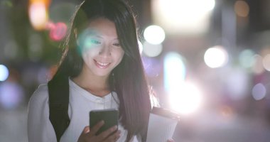 Kahve kağıt bardak holding ile gece Taipei city cep telefonu kullanan kadın