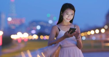 Asyalı kadın geceleri cep telefonu kullanarak