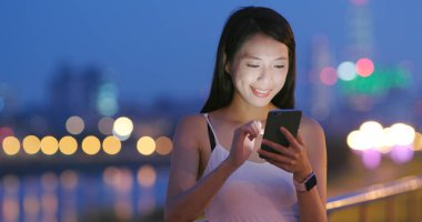 Akşam cep telefonu kullanan genç kadın