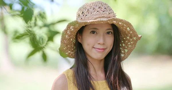 妇女戴草帽 微笑着在公园里拍照 — 图库照片