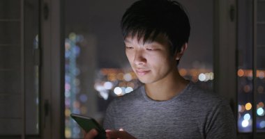 Evde cep telefonu kullanan adam. 