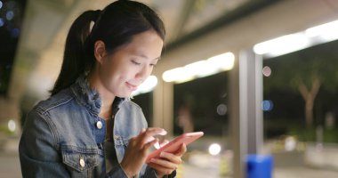 cep telefonuyla şehirde gece kadın