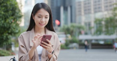 Cep telefonu açık, üzerinde çalışan genç kadın