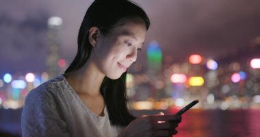 Geceleri cep telefonu kullanan kadın