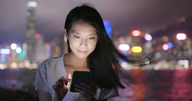 cep telefonuyla şehirde gece kadın