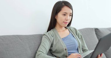 Ev kadını evde dizüstü bilgisayar üzerinde çalışan