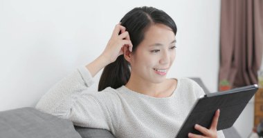 evde tablet bilgisayar kullanan kadın