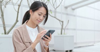 Akıllı telefon kullanan genç bir kadın.