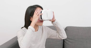 Evde VR aygıtla arayan kadın