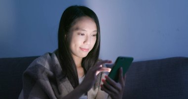 Cep telefonu evde akşamları kullanan kadın