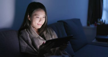 Akşamları evde tablet bilgisayar kullanan kadın