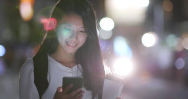 Kahve kağıt bardak holding ile gece Taipei city cep telefonu kullanan kadın