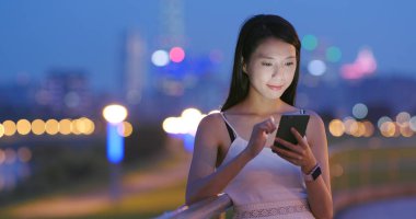 Akşam cep telefonu kullanan genç kadın